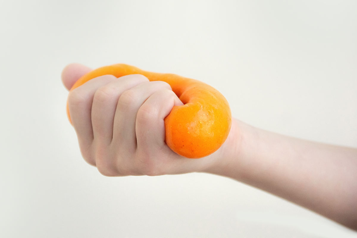 mano aprieta una masa de slime casero hecho con cola